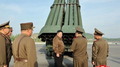 朝中社周六发布这张于周五拍摄的照片，显示金正恩在朝鲜一处秘密地点检查240毫米口径多管火箭发射器系统。（图取自朝中社/法新社）