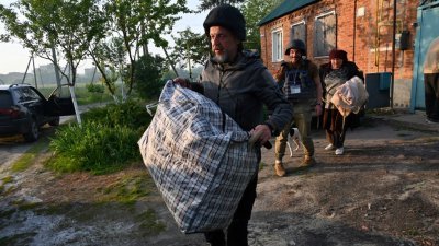 乌克兰志工周五在哈尔科夫地区北部协助居民撤离。（图取自法新社）