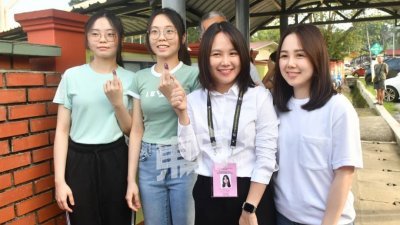彭小桃（右2）与孪生姐姐彭筱茵（右）在投票站巧遇一对完成投票的双胞胎姐妹陈雪儿和陈雪妮，不忘了合影留念。