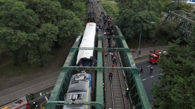 一列客运列车与一列维修列车，周五在阿根廷首都布宜诺斯艾利斯一座铁路桥上相撞，其中一列列车车头严重损毁，赶到现场的紧急部门人员在现场救援。（图取自法新社）