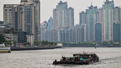 一艘船驶过上海黄浦江。（图取自法新社）