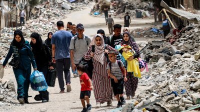 以色列和哈马斯持续发生冲突，流离失所的巴勒斯坦人周六从加沙地带北部的塔尔扎塔尔巴勒斯坦难民营撤离。（图取自法新社）