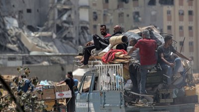 逃离加沙地带南部城市拉法的巴勒斯坦人，在周日坐著货车运载家当抵达汗尤尼斯避难。（图取自法新社）