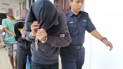 2名被告（右2及3）被警员押离法庭时，以带帽衣服遮脸避开媒体镜头。