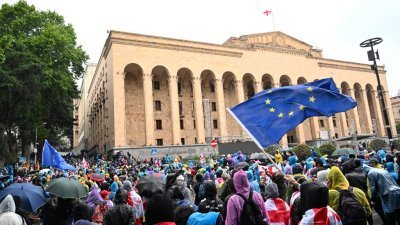 反对《外国影响透明度法案》的示威者，周一在格鲁吉亚首都第比利斯议会外举行抗议，场中有人挥舞欧盟的旗帜。（图取自法新社）