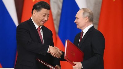 2023年3月21日，中国国家主席习近平与俄罗斯总统普京在里姆林宫会谈后，在签字仪式上握手。（图取自法新档案照）