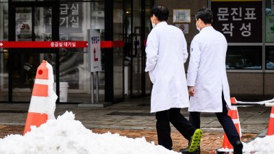 在韩国首尔，两名医生在医院外行走。（图取自法新社档案照）