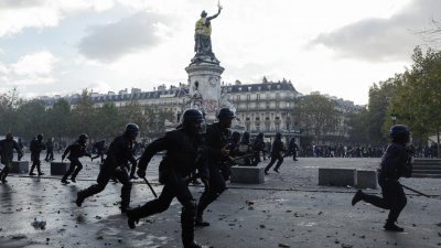 上周六在巴黎共和国广场，警察在抗议“高昂生活成本”的示威活动中向前推进。（图取自法新社）