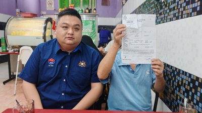 黄国华手持报案书，在徐安岄(左)陪同下，召开新闻发布会。