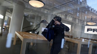 法国北部城市里尔周日的抗议“高昂生活成本”示威演变成暴动，一名男子趁乱在苹果商店抢走一架苹果萤幕。（图取自法新社）