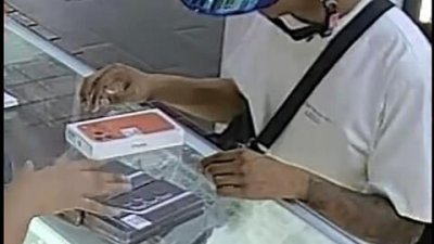 戴著头盔的青年当众抢走手机后逃逸。 （受访者提供）