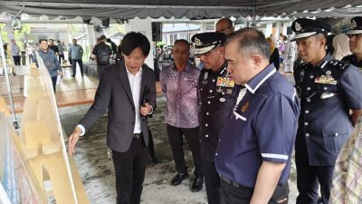 陆兆福（右）聆听主办单位讲解“安全校园区试点计划”。