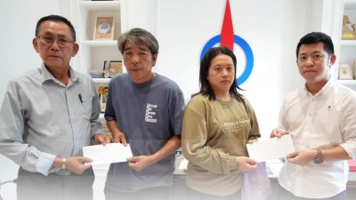 姜常福夫妇（左2起）接领实兆远民主行动党代收的11万7655令吉55仙善款，以及霹雳州民主行动党拨出的1万令吉援助金。右为黄天荣。（图取自黄天荣面书）