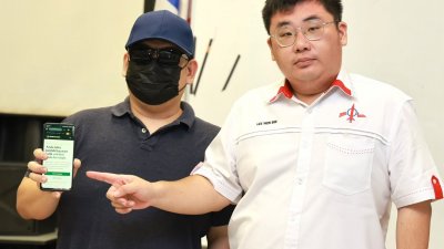 潘先生（左）在李文彬（右）的陪同下在记者会上，展示网上借贷平台的页面，揭露相关贷款的申请及收费资讯。