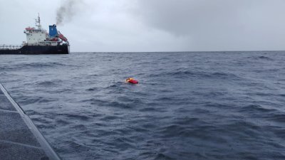 一名挖沙船船员在海上漂流，等待救援。（图由海事执法机构提供）