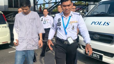 身穿病服及赤脚的被告（左），在警方押送下抵达法庭面控。