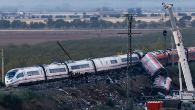 西班牙国家铁路公司（Renfe）的列车（左）周三在托莱多省乌尔达和洛斯耶韦内斯之间的铁路线上，追撞西班牙私营铁路公司伊尔约（Iryo）一辆停在轨道上的列车。调查人员周四在受损车厢中勘察碎片。（图取自法新社）