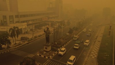 10月15日，印尼中加里曼丹省帕朗卡拉亚笼罩在野火产生的浓烟与烟霾中，一片灰橙色。（图取自法新社）

