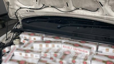 执法人员在车内多个经过改装暗格中发现超过400条及30包漏税香烟。 （新加坡取自移民与关卡局面子书）