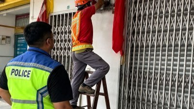警方联合国能职员对违规店面进行断电行动。（图取自居銮警方面子书）