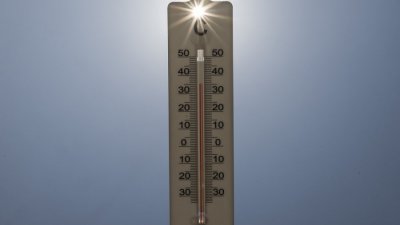 8月14日下午，在法国北部加来海峡省的蒙特勒伊，阳光穿过一个读数为摄氏35度的家用温度计。（图取自法新社档案照）