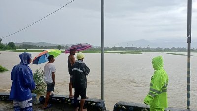 在菲律宾北部南伊罗戈省圣卢西亚市，当地救灾人员周日在帕拉通社区一座大桥上查看水情。（图取自菲律宾圣卢西亚市警察局/中新社）