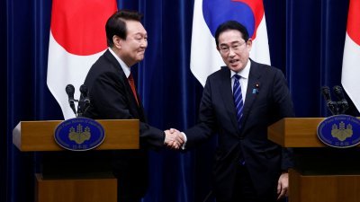 韩国总统尹锡悦3月16日访问日本，与日本首相岸田文雄在东京首相官邸举行的联合新闻发布会上握手。（图取自路透社）
