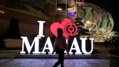2019年12月21日，一名女子走过澳门新葡京酒店和赌场旁边的中国银行分行。（图取自路透社档案照）