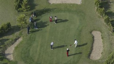 2004年5月1日，中国游客在在朝鲜首都平壤的一个高尔夫球场打高尔夫球。（图取自路透社档案照）


